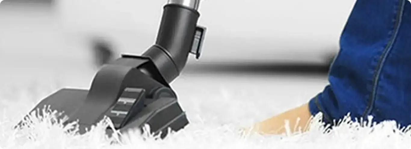 Close-up of a professional vacuuming a white carpet in Penrose.